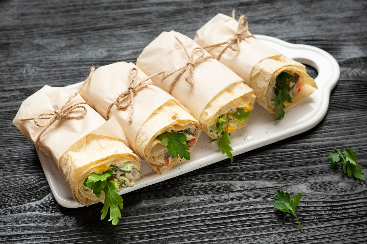 Food wraps tied with twine on a serving tray